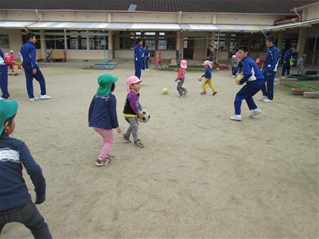 中学生と園庭で遊ぶ子どもたち