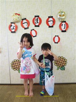 夏祭りでお土産をたくさんもらって写真におさまっている