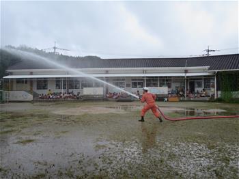 園庭で放水作業を見学している写真