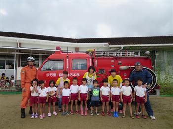 消防車の前で子供たちが立っている写真
