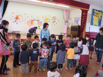 まつ組さんが小さい組さんにお別れのプレゼントを渡している写真