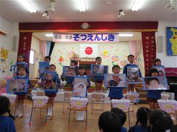 まつ組さんが赤ちゃんの写真を持っている写真