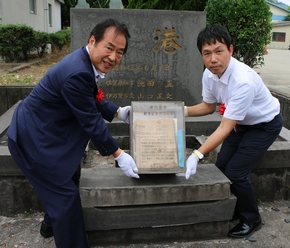 タイムカプセルを取り出す塚部市長(左)と当時誕生され石碑に名前が刻まれた立会人
