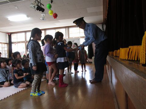 お巡りさんに交通マスコットを手渡し