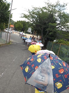 傘をさして避難している様子