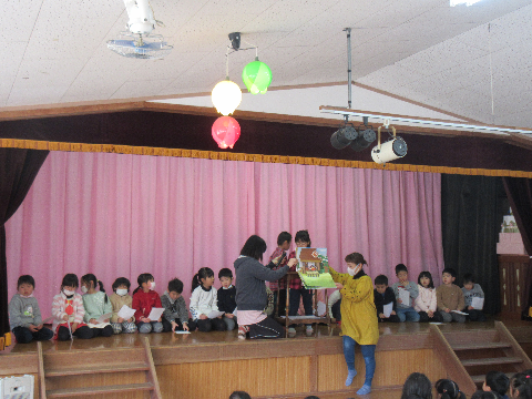 ステージで紙芝居の読み聞かせをする園児