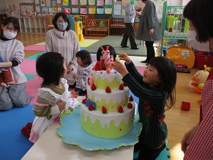 布製ケーキの飾りつけを楽しんでいる