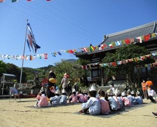 鯉のぼりの前で市長さんの話をきく子どもたち