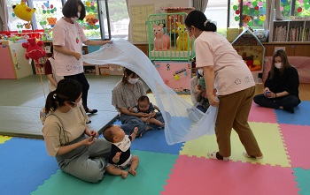 シフォンの布でふんわり包まれる親子の様子