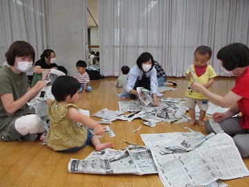新聞紙を破って遊ぶ様子