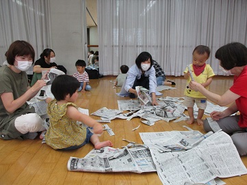 新聞紙を破って遊ぶ様子