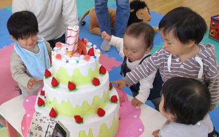 ケーキのイチゴをつまもうとしているベビーちゃん