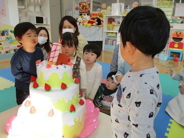 誕生日ケーキのろうそくを吹き消す真似をしている様子