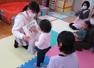 絵本のケーキを食べる真似をしている子