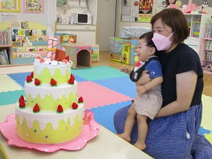 ケーキの火が消えるしかけに驚く親子