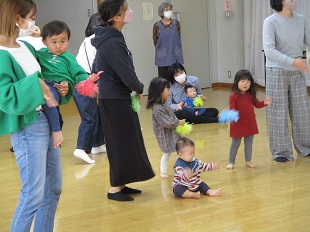 ポンポンを持って踊る親子のようす