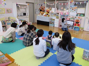 アリスさんのお話を楽しむ親子のようす