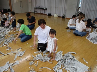 破った新聞紙を被る親子のようす