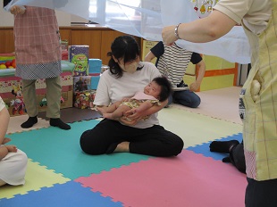 シフォンの布にふんわり包まれる親子のようす