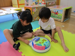 仲良くなったお友だちと一緒に電車のおもちゃで遊んでいるようす