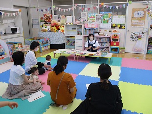 図書館司書さんのお話を熱心にきく親子のようす