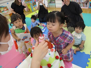 ケーキのろうそくを吹き消すお友だち