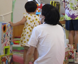ボールプールに入る手伝いをしているパパ
