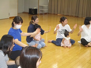 円になって手遊びを楽しんでいるようす