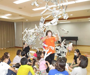 新聞紙の雨をまとうセンター長