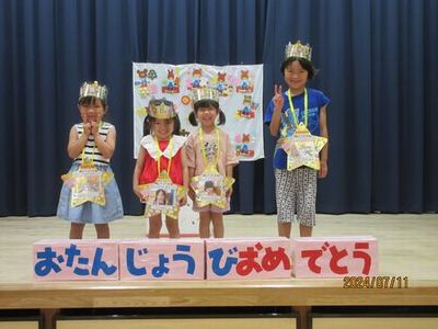 ケーキの前で集合写真を撮っています