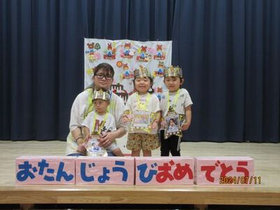 ケーキの前で集合写真を撮っています