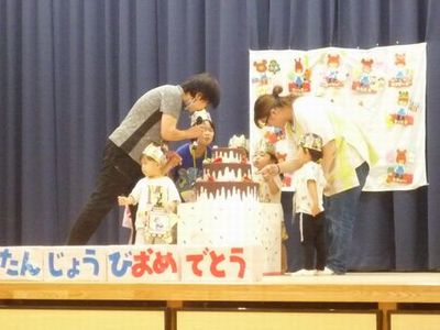 みんなでケーキを囲んでろうそくを吹き消している所です