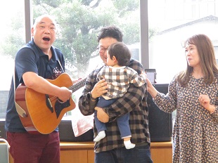 誕生月の歌に合わせて前で記念撮影する様子
