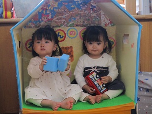 絵本の部屋に座っている双子ちゃん