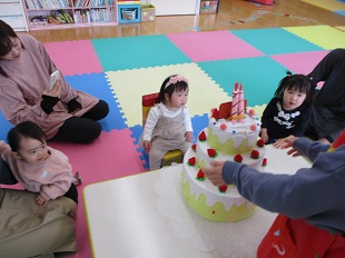 ケーキのろうそくの火を吹き消す真似をするお友だち