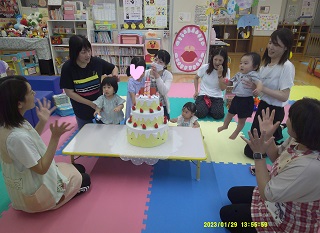 誕生会でケーキを囲んでいる様子